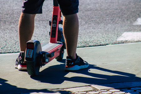 Seville Spain September 18, 2021 People rolling with an electric scooter in the streets of Seville, operating with a small utility internal combustion engines and a deck in the centerのeditorial素材