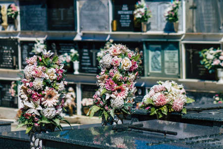 Seville Spain September 21, 2021 Typical graves in a Christian cemetery of the municipality of Carmona in Andalusia in southern Spain, the graves are made in the depth of a wall and richly decoratedのeditorial素材
