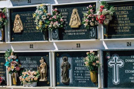 Seville Spain September 21, 2021 Typical graves in a Christian cemetery of the municipality of Carmona in Andalusia in southern Spain, the graves are made in the depth of a wall and richly decoratedのeditorial素材