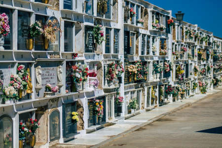 Seville Spain September 21, 2021 Typical graves in a Christian cemetery of the municipality of Carmona in Andalusia in southern Spain, the graves are made in the depth of a wall and richly decoratedのeditorial素材