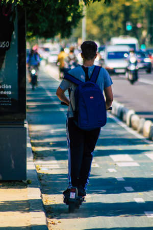 Seville Spain September 28, 2021 People rolling with an electric scooter in the streets of Seville, operating with a small utility internal combustion engines and a deck in the centerの写真素材