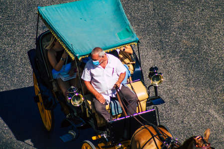 Seville Spain September 04, 2021 Horse drawn carriage ride through the streets of Seville during the coronavirus outbreak hitting Spain, wearing a mask is mandatoryのeditorial素材