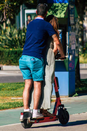 Seville Spain September 04, 2021 People rolling with an electric scooter in the streets of Seville, operating with a small utility internal combustion engines and a deck in the centerのeditorial素材