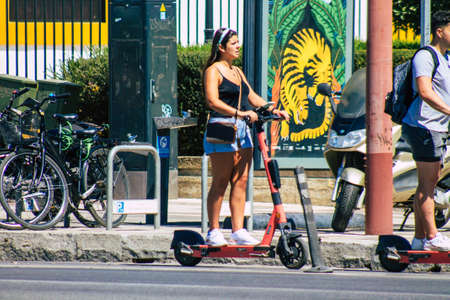 Seville Spain September 04, 2021 People rolling with an electric scooter in the streets of Seville, operating with a small utility internal combustion engines and a deck in the centerのeditorial素材