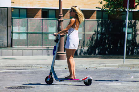 Seville Spain September 04, 2021 People rolling with an electric scooter in the streets of Seville, operating with a small utility internal combustion engines and a deck in the centerのeditorial素材