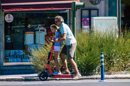 Seville Spain September 04, 2021 People rolling with an electric scooter in the streets of Seville, operating with a small utility internal combustion engines and a deck in the centerのeditorial素材