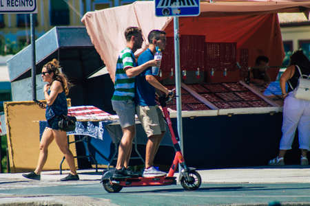 Seville Spain September 04, 2021 People rolling with an electric scooter in the streets of Seville, operating with a small utility internal combustion engines and a deck in the centerのeditorial素材