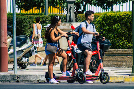 Seville Spain September 04, 2021 People rolling with an electric scooter in the streets of Seville, operating with a small utility internal combustion engines and a deck in the centerのeditorial素材
