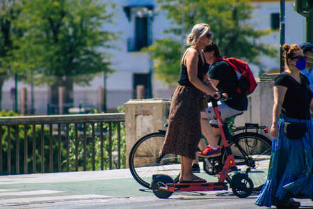 Seville Spain September 04, 2021 People rolling with an electric scooter in the streets of Seville, operating with a small utility internal combustion engines and a deck in the centerのeditorial素材