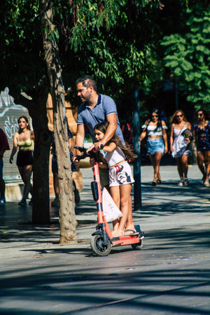 Seville Spain September 04, 2021 People rolling with an electric scooter in the streets of Seville, operating with a small utility internal combustion engines and a deck in the centerのeditorial素材