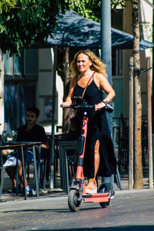 Seville Spain September 04, 2021 People rolling with an electric scooter in the streets of Seville, operating with a small utility internal combustion engines and a deck in the centerのeditorial素材