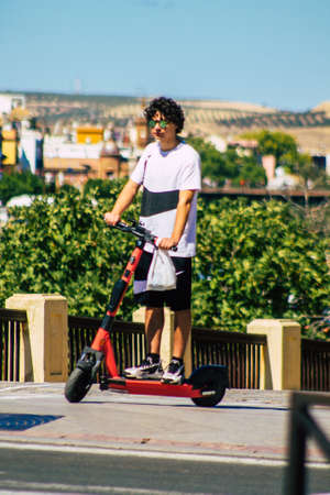 Seville Spain September 18, 2021 People rolling with an electric scooter in the streets of Seville, operating with a small utility internal combustion engines and a deck in the centerのeditorial素材
