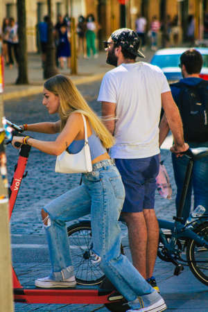Seville Spain September 18, 2021 People rolling with an electric scooter in the streets of Seville, operating with a small utility internal combustion engines and a deck in the centerのeditorial素材