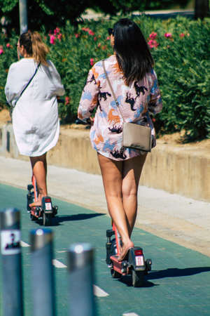 Seville Spain September 18, 2021 People rolling with an electric scooter in the streets of Seville, operating with a small utility internal combustion engines and a deck in the centerのeditorial素材