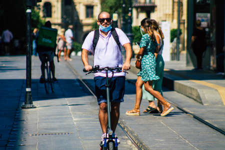 Seville Spain September 18, 2021 People rolling with an electric scooter in the streets of Seville, operating with a small utility internal combustion engines and a deck in the centerのeditorial素材