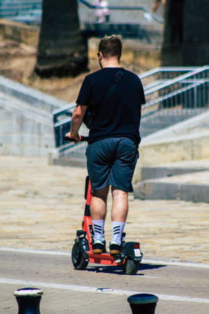 Seville Spain September 18, 2021 People rolling with an electric scooter in the streets of Seville, operating with a small utility internal combustion engines and a deck in the centerのeditorial素材