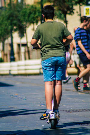 Seville Spain September 18, 2021 People rolling with an electric scooter in the streets of Seville, operating with a small utility internal combustion engines and a deck in the centerのeditorial素材