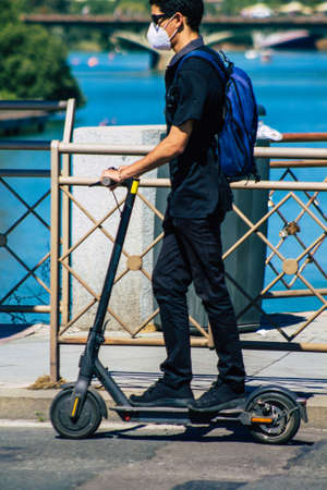 Seville Spain September 18, 2021 People rolling with an electric scooter in the streets of Seville, operating with a small utility internal combustion engines and a deck in the centerのeditorial素材