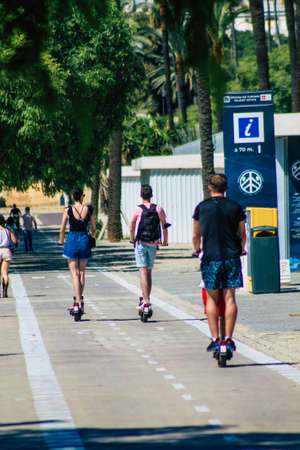 Seville Spain September 18, 2021 People rolling with an electric scooter in the streets of Seville, operating with a small utility internal combustion engines and a deck in the centerのeditorial素材