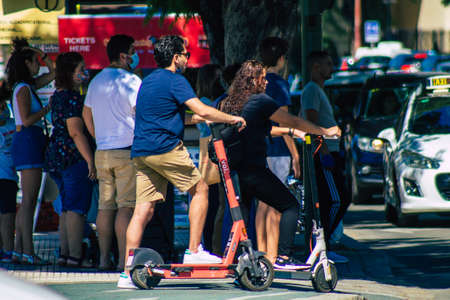 Seville Spain September 18, 2021 People rolling with an electric scooter in the streets of Seville, operating with a small utility internal combustion engines and a deck in the centerのeditorial素材