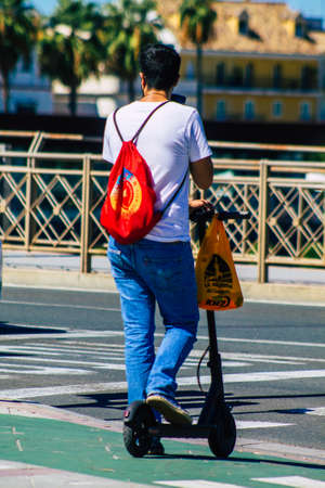 Seville Spain September 18, 2021 People rolling with an electric scooter in the streets of Seville, operating with a small utility internal combustion engines and a deck in the centerのeditorial素材