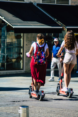 Seville Spain September 18, 2021 People rolling with an electric scooter in the streets of Seville, operating with a small utility internal combustion engines and a deck in the centerのeditorial素材