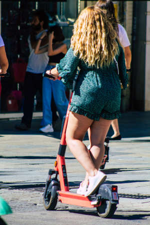 Seville Spain September 18, 2021 People rolling with an electric scooter in the streets of Seville, operating with a small utility internal combustion engines and a deck in the centerのeditorial素材
