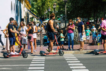 Seville Spain September 18, 2021 People rolling with an electric scooter in the streets of Seville, operating with a small utility internal combustion engines and a deck in the centerのeditorial素材