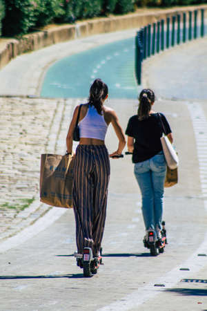 Seville Spain September 18, 2021 People rolling with an electric scooter in the streets of Seville, operating with a small utility internal combustion engines and a deck in the centerのeditorial素材
