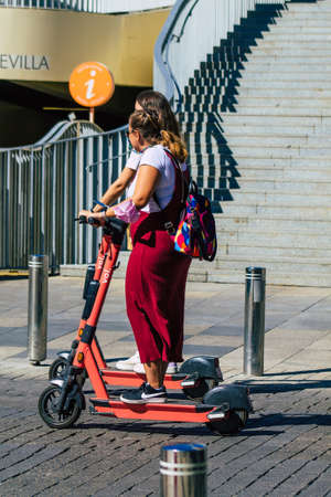 Seville Spain September 18, 2021 People rolling with an electric scooter in the streets of Seville, operating with a small utility internal combustion engines and a deck in the centerのeditorial素材