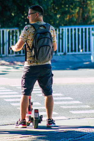 Seville Spain September 18, 2021 People rolling with an electric scooter in the streets of Seville, operating with a small utility internal combustion engines and a deck in the centerのeditorial素材