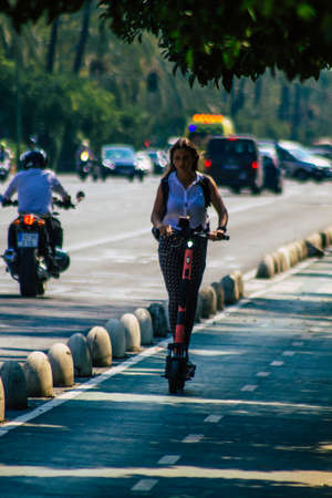 Seville Spain September 28, 2021 People rolling with an electric scooter in the streets of Seville, operating with a small utility internal combustion engines and a deck in the centerのeditorial素材