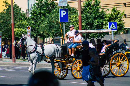 Seville Spain September 18, 2021 Horse drawn carriage ride through the streets of Seville during the coronavirus outbreak hitting Spain, wearing a mask is mandatoryのeditorial素材