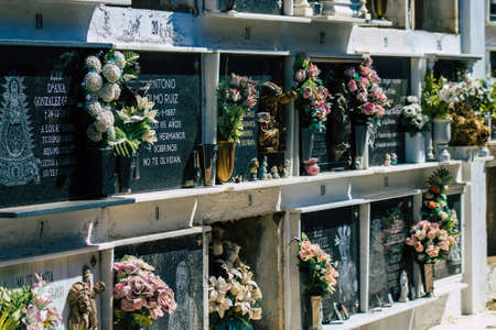 Seville Spain September 21, 2021 Typical graves in a Christian cemetery of the municipality of Carmona in Andalusia in southern Spain, the graves are made in the depth of a wall and richly decoratedのeditorial素材