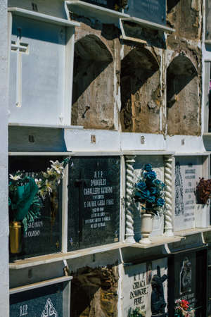 Seville Spain September 21, 2021 Typical graves in a Christian cemetery of the municipality of Carmona in Andalusia in southern Spain, the graves are made in the depth of a wall and richly decoratedのeditorial素材
