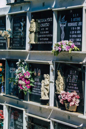 Seville Spain September 21, 2021 Typical graves in a Christian cemetery of the municipality of Carmona in Andalusia in southern Spain, the graves are made in the depth of a wall and richly decoratedのeditorial素材