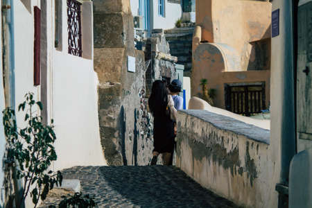 Santorini, Oia, Greece - October 24, 2021 Crowd of tourists visiting the famous perched town of Oia during the coronavirus epidemic hitting Greece, wearing a mask in the street is not mandatoryのeditorial素材