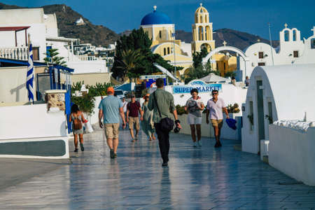 Santorini, Oia, Greece - October 24, 2021 Crowd of tourists visiting the famous perched town of Oia during the coronavirus epidemic hitting Greece, wearing a mask in the street is not mandatoryのeditorial素材