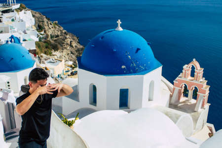 Santorini, Oia, Greece - October 24, 2021 Crowd of tourists visiting the famous perched town of Oia during the coronavirus epidemic hitting Greece, wearing a mask in the street is not mandatoryのeditorial素材