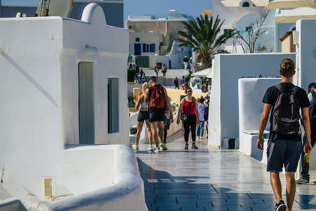 Santorini, Oia, Greece - October 24, 2021 Crowd of tourists visiting the famous perched town of Oia during the coronavirus epidemic hitting Greece, wearing a mask in the street is not mandatoryのeditorial素材