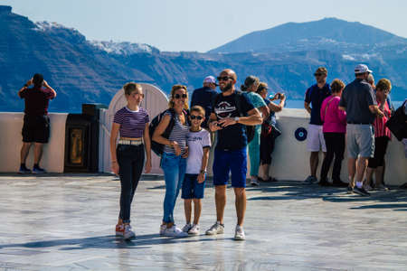 Santorini, Oia, Greece - October 24, 2021 Crowd of tourists visiting the famous perched town of Oia...