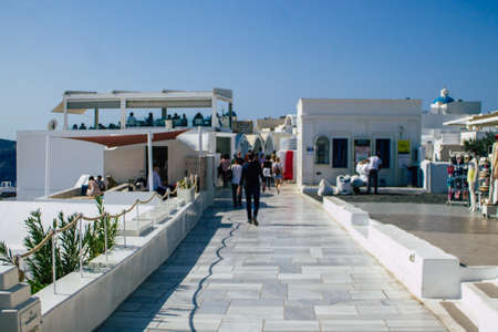 Santorini, Oia, Greece - October 24, 2021 Crowd of tourists visiting the famous perched town of Oia...