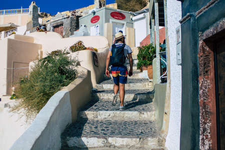 Santorini, Oia, Greece - October 24, 2021 Crowd of tourists visiting the famous perched town of Oia during the coronavirus epidemic hitting Greece, wearing a mask in the street is not mandatoryのeditorial素材