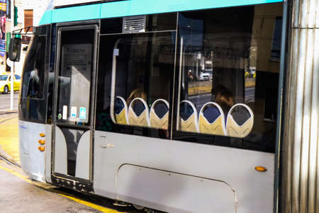 Athens, Greece - November 22, 2021 Modern electric tram for passengers rolling through the streets of Athens during the coronavirus outbreak hitting Greece, wearing a mask is mandatoryのeditorial素材