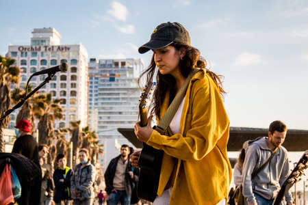 Tel Aviv, Israel - March 06, 2022 Young independent singer doing a music concert on the promenade facing the sea in Tel Aviv, artists are known in this way and sell their records at the same timeのeditorial素材