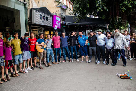 Tel Aviv, Israel - April 08, 2022 Following the Palestinian terrorist attack at the Ilka Bar on Dizengoff Street, young Israeli teenagers singing at the site of the attackのeditorial素材