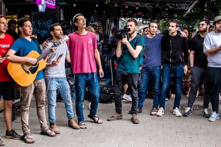 Tel Aviv, Israel - April 08, 2022 Following the Palestinian terrorist attack at the Ilka Bar on Dizengoff Street, young Israeli teenagers singing at the site of the attackのeditorial素材
