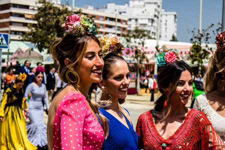 Seville, Spain - May 01, 2022 Sevillians dressed in traditional Andalusian way strolling the aisles of the Feria de Seville, This celebration is back after two years of absence due to covid epidemicのeditorial素材