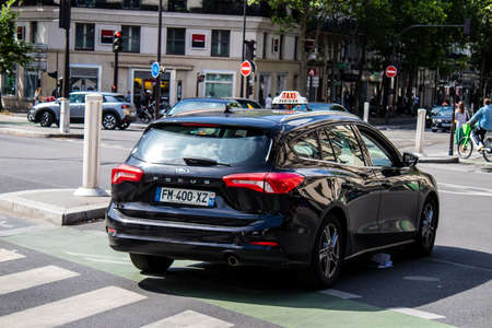 Paris, France - May 21, 2022 Taxi driving through the streets of Paris during the coronavirus...