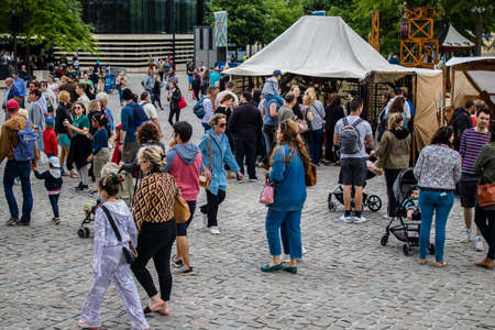 Reims, France - May 28, 2022 Visitors wandering the aisles of the medieval market during Johanniques...